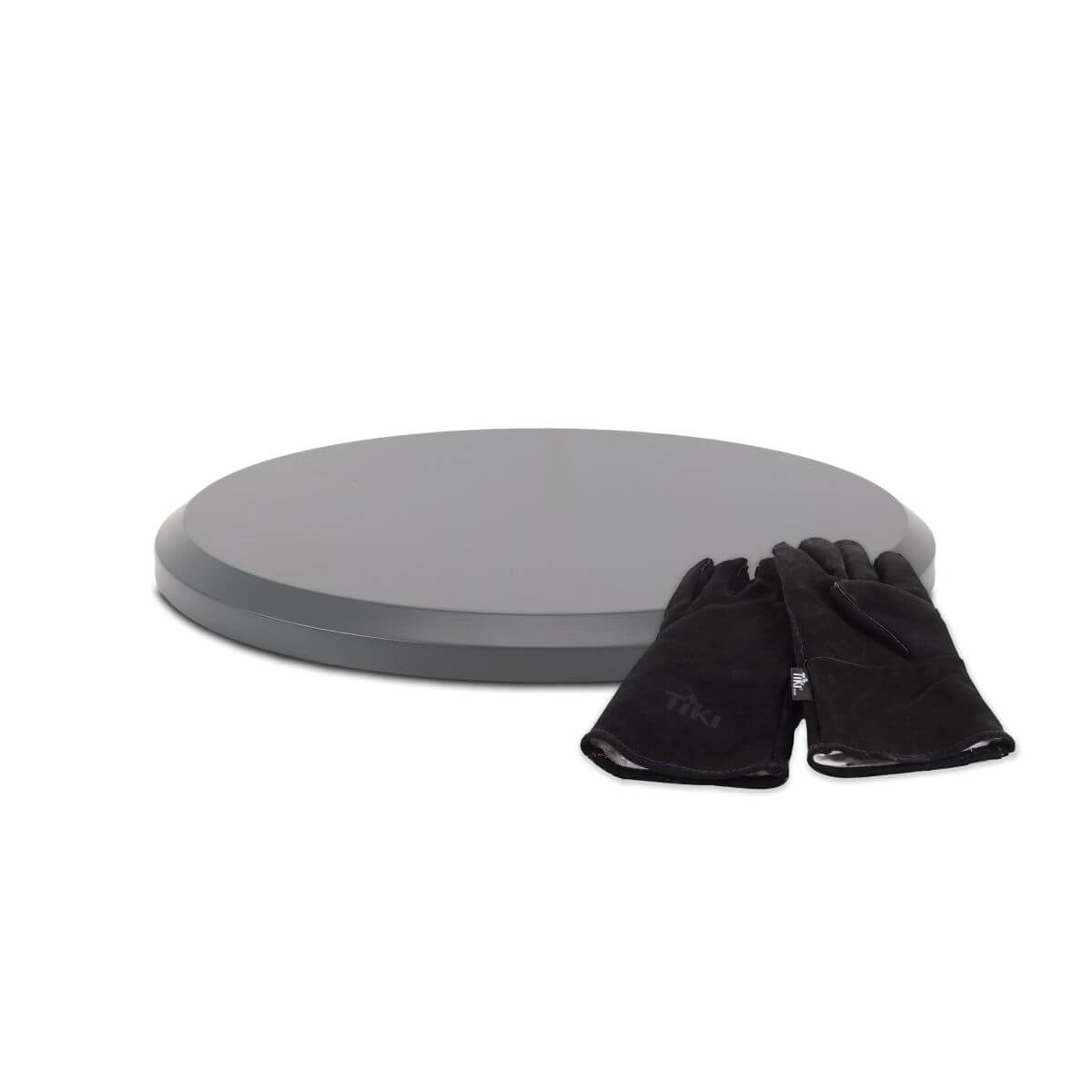 Round fire pit cover with a pair of black TIKI-brand heat-resistant gloves placed on top.