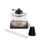 TIKI® tabletop fire pit replacement parts: glass canister, wick, and snuffer cap on a wood-look base.