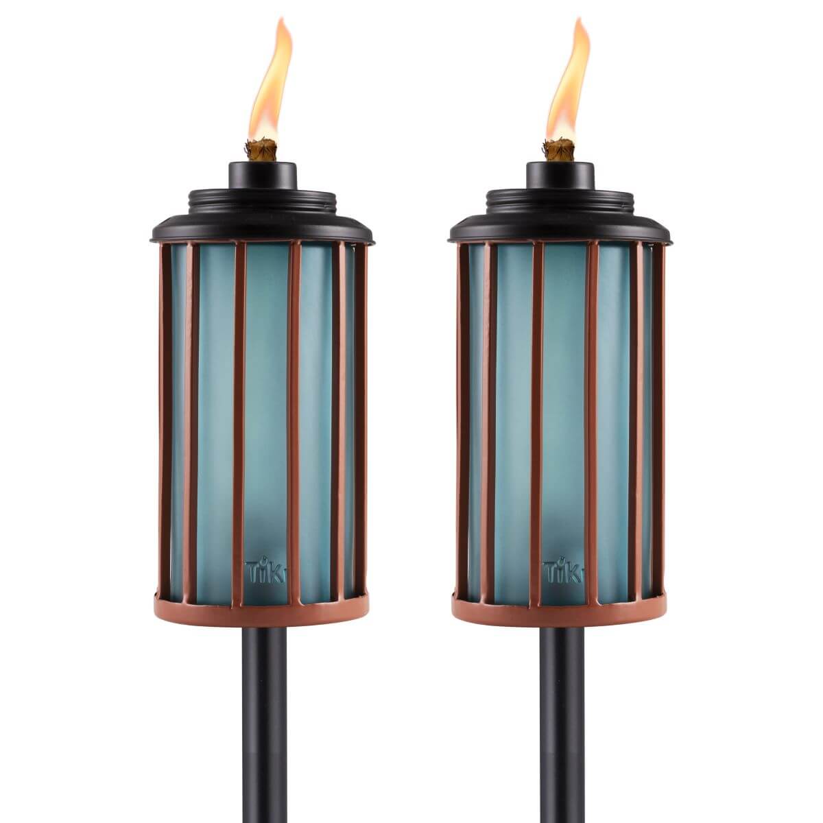 Pair of TIKI Brand outdoor torches with blue glass and bronze metal accents, each lit with a visible flame.