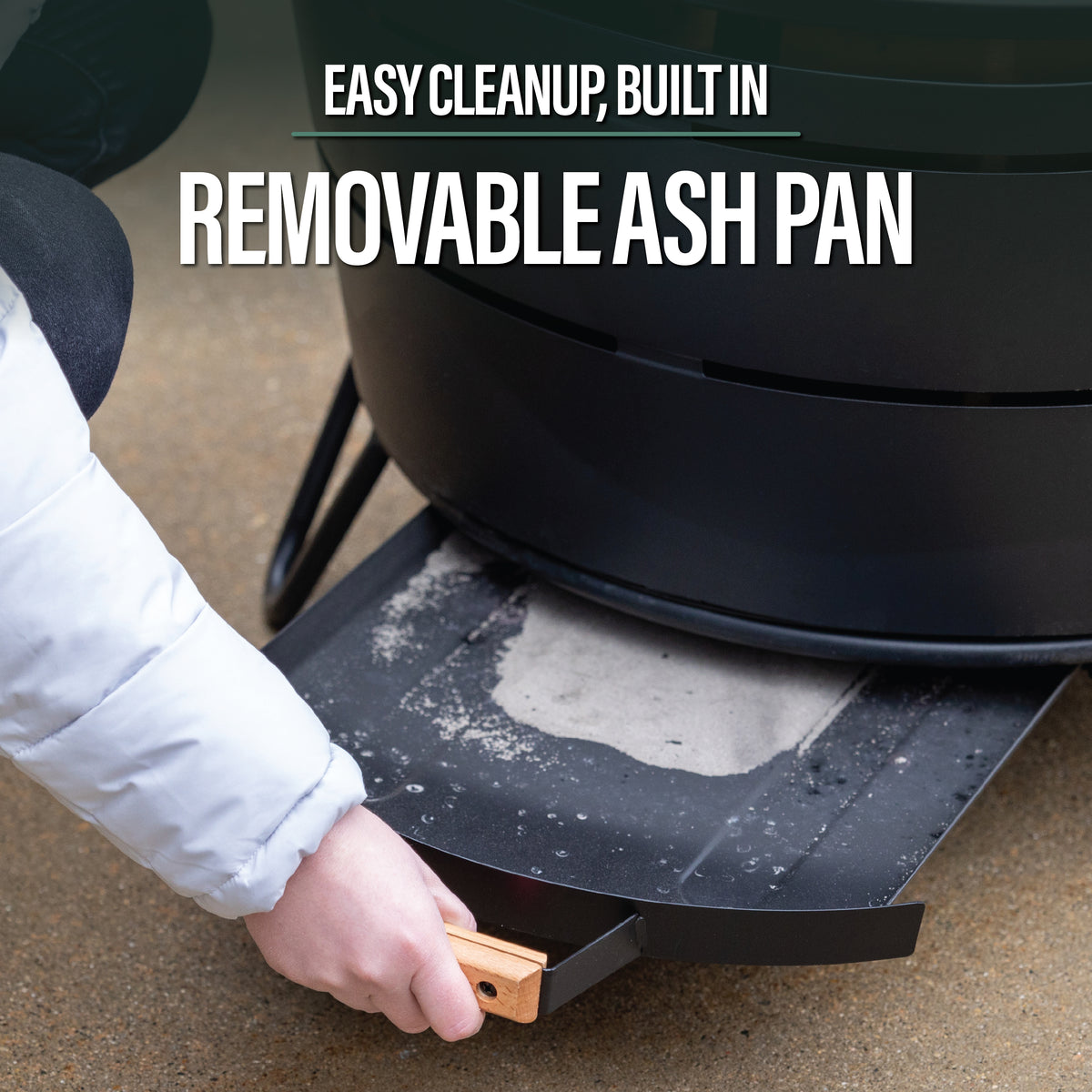 TIKI Brand Reunion Smokeless Fire Pit with removable ash pan being pulled out for easy cleanup