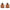 Set of two brown ribbed ceramic Tiki torches with black tops and visible flames, ideal for outdoor ambiance.