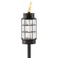 Black metal and glass TIKI® Brand torch with a visible flame, designed for outdoor lighting and ambiance.