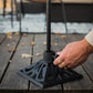 Black cast iron patio umbrella base with hand tightening knob.