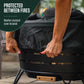 Round black fire pit with a weather-resistant cover being placed on top; Tiki brand label visible.