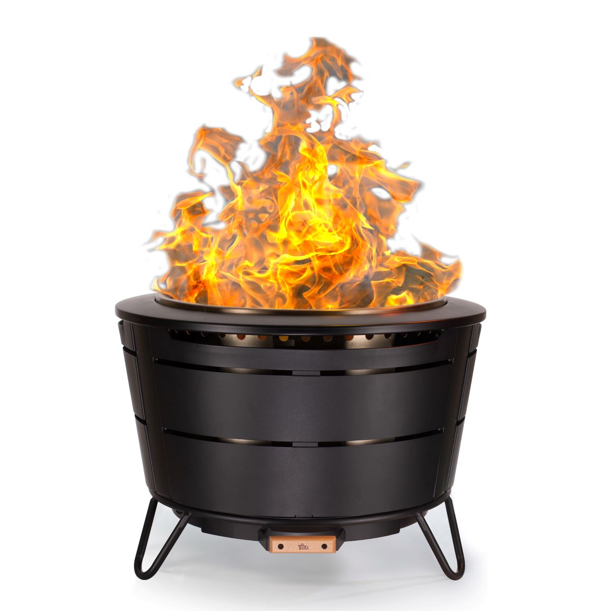 Black TIKI fire pit with bright flames, designed for outdoor use; sturdy metal legs and vented sides for airflow.