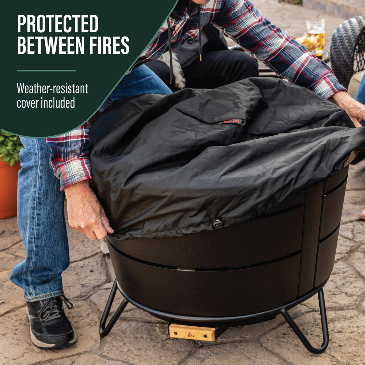 TIKI Brand Reunion Smokeless Fire Pit with included weather-resistant cloth cover being placed on top