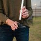 Person inserting a replacement wick into a TIKI Brand torch cap outdoors.