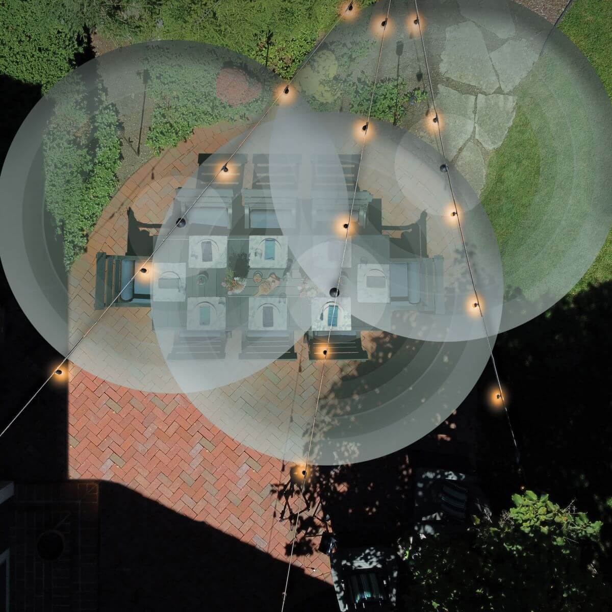 Overhead view of patio dining area with TIKI string lights, showing illuminated coverage zones for outdoor gatherings.