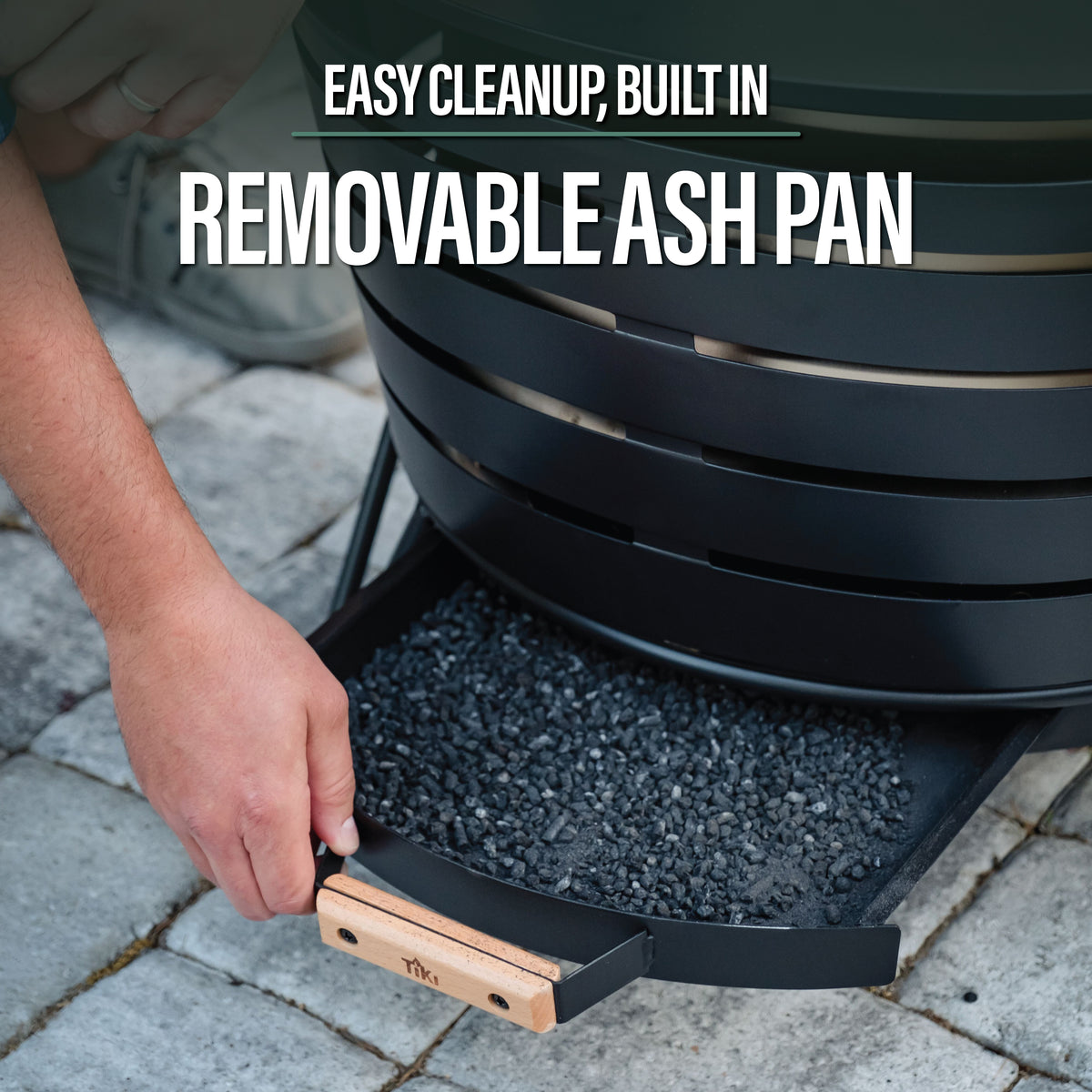 Black fire pit with a built-in removable ash pan for easy cleanup. Wooden handle for accessible grip.