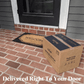 A TIKI Brand Fire Pit Wood Pack box sits on a brick porch by a welcome mat, ready for doorstep delivery.