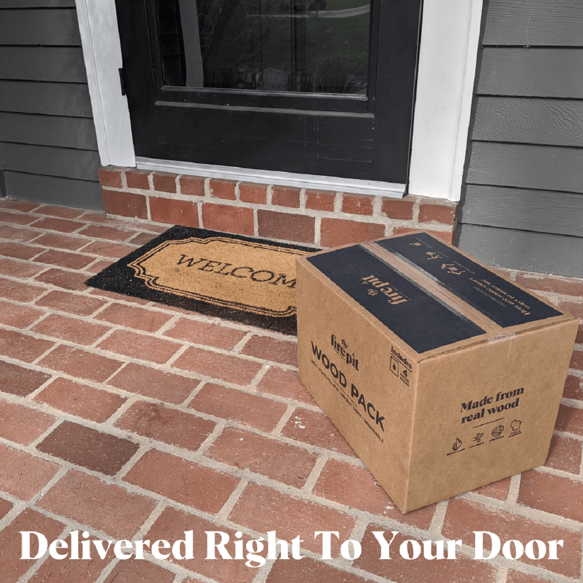 A TIKI Brand Fire Pit Wood Pack box sits on a brick porch by a welcome mat, ready for doorstep delivery.