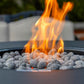Outdoor fire pit with glowing orange flames and gray lava rocks.