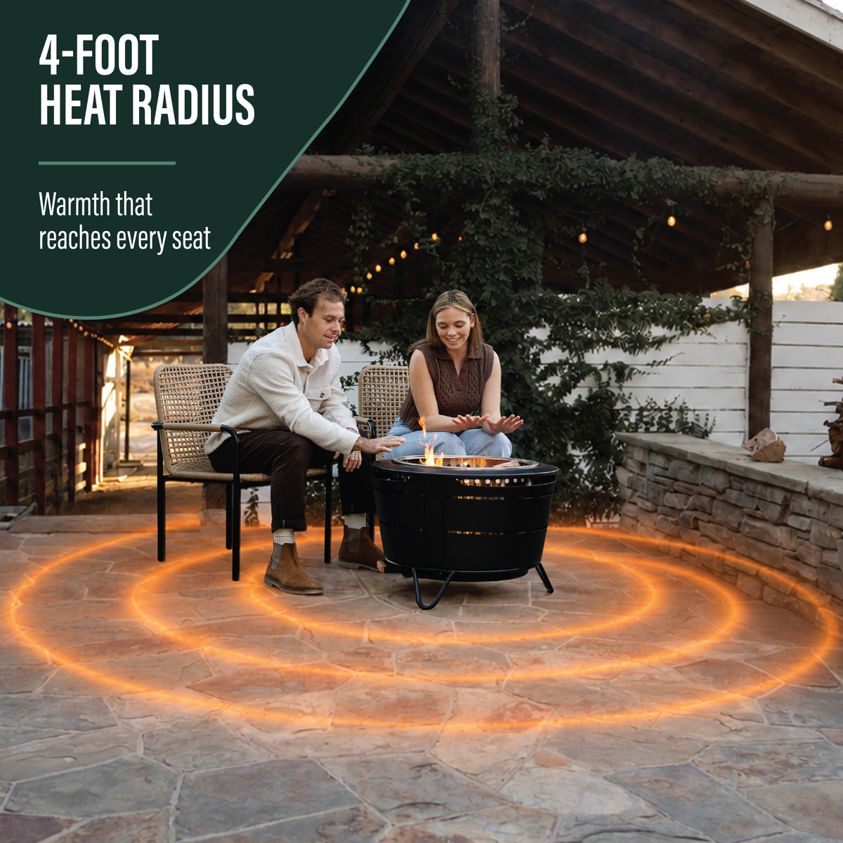 TIKI Brand Reunion Smokeless Fire Pit, outdoor use with two people seated showing 4-foot heat radius